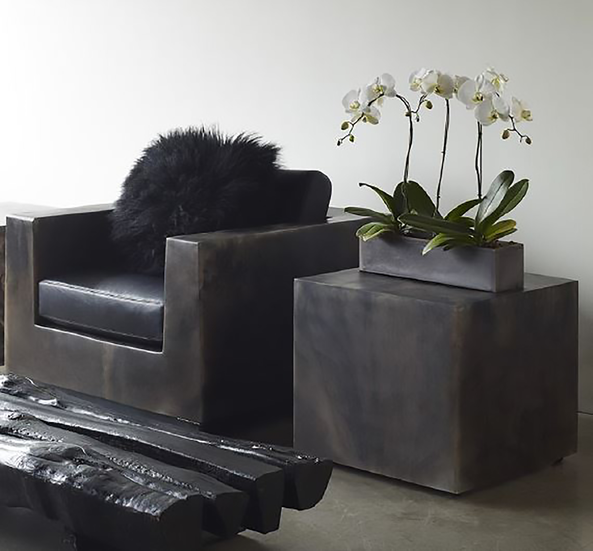 preston clay and black marble chair with fuzzy black cushion and resin side table with white orchid displayed